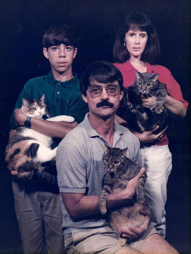 Awkward family posing with a cat.